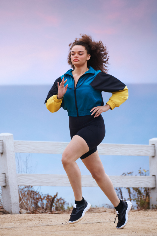 Active woman jogging on a trail overlooking the ocean