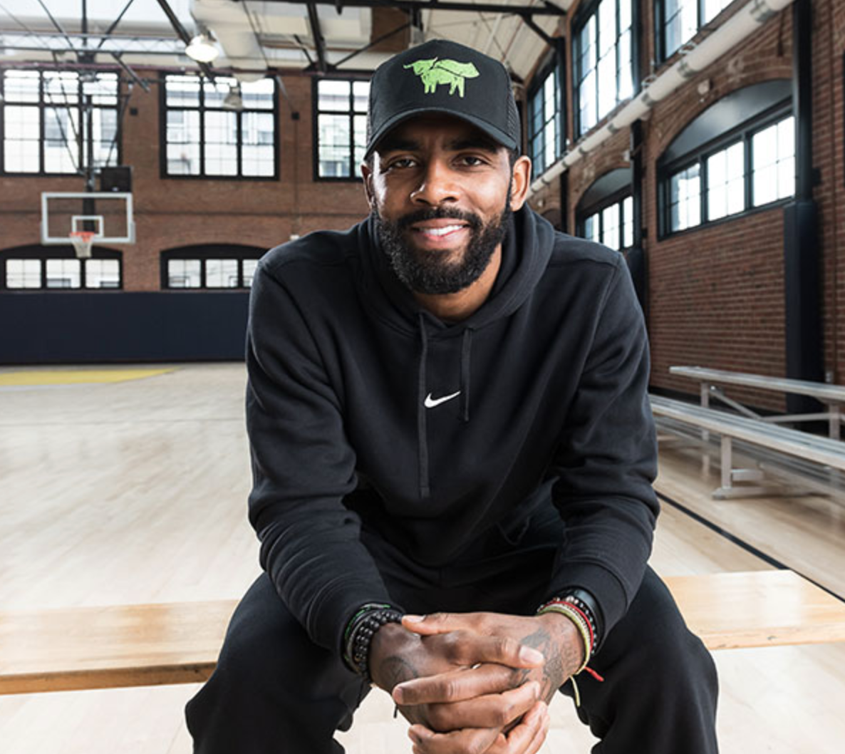 Kyrie Irving Beyond Ambassador sitting on a basketball court